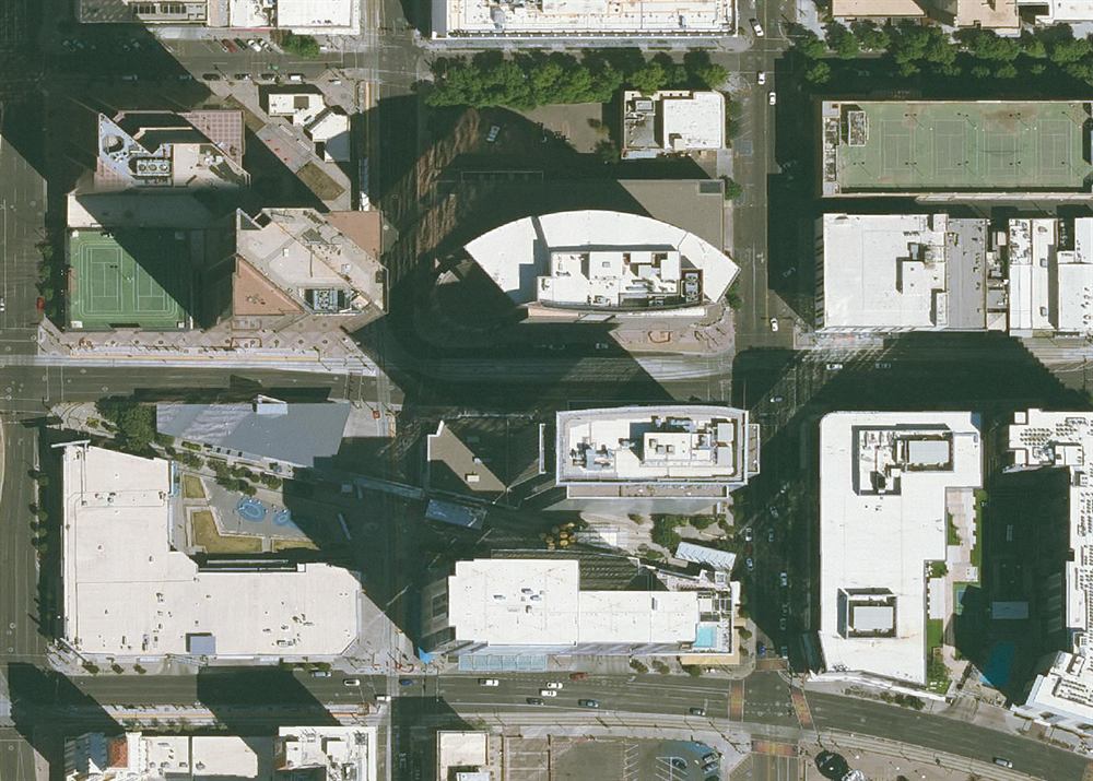 Zoomed satellite view - two matching fleet trucks parked side by side at the job